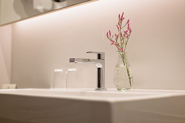 Elegantes Waschbecken mit dekorativer Blumenvase
