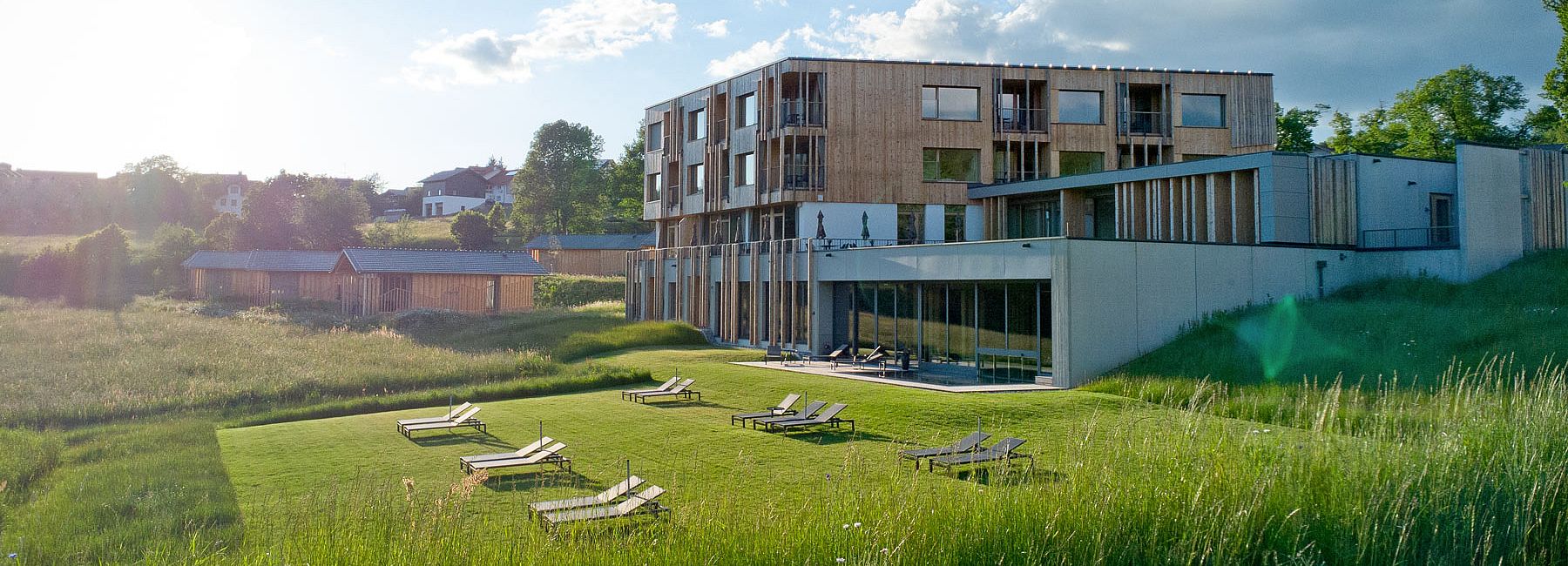 Liegewiese vor dem Naturhotel Euler Neuschönau mit Chalets Woidhaisl im Sommer