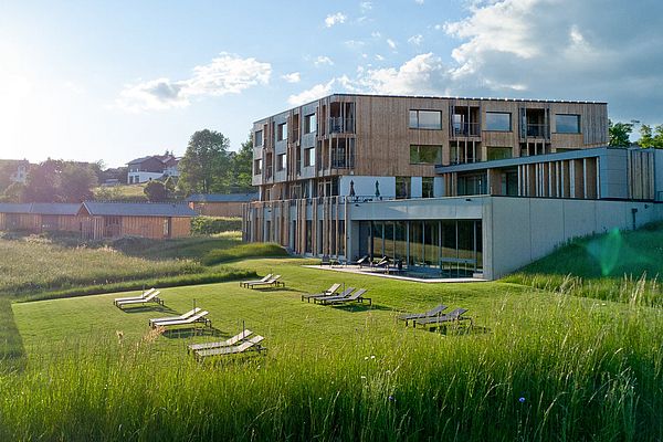 Liegewiese vor dem Naturhotel Euler Neuschönau mit Chalets Woidhaisl im Sommer