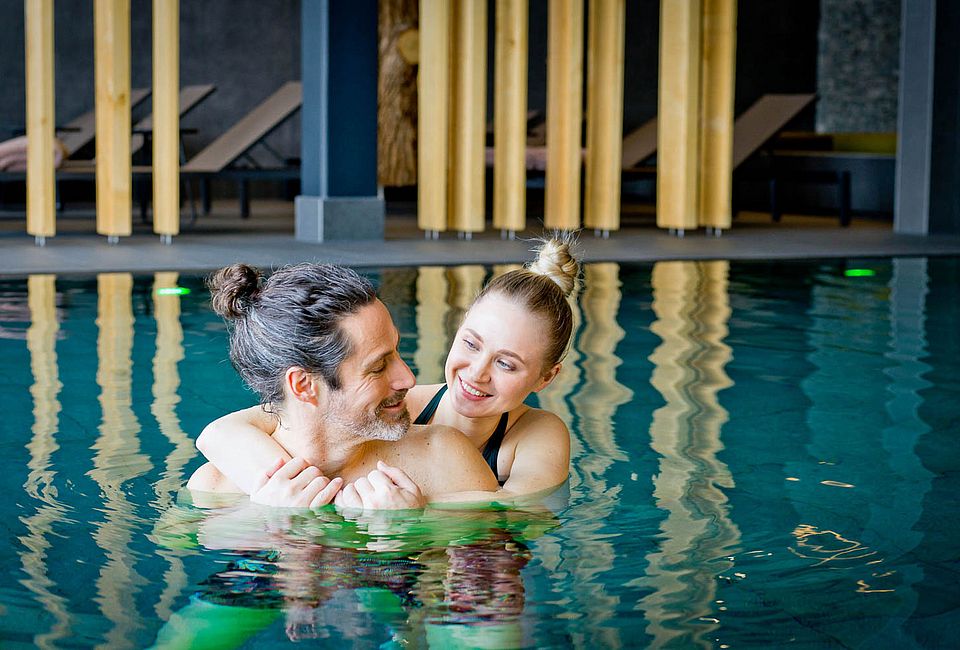 Couple embracing while relaxing in the indoor spa pool