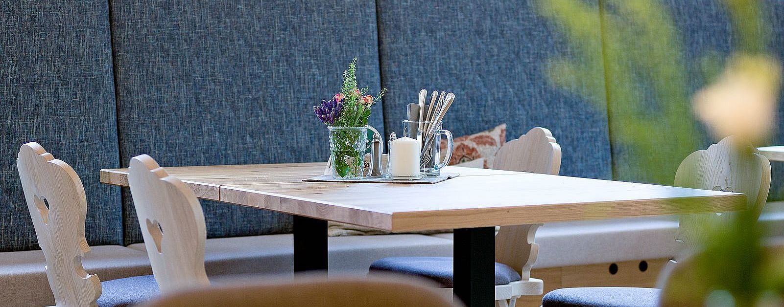 Tisch mit Blumenschmuck und gemütlicher Sitzgarnitur im Restaurant des Euler Landgasthofs