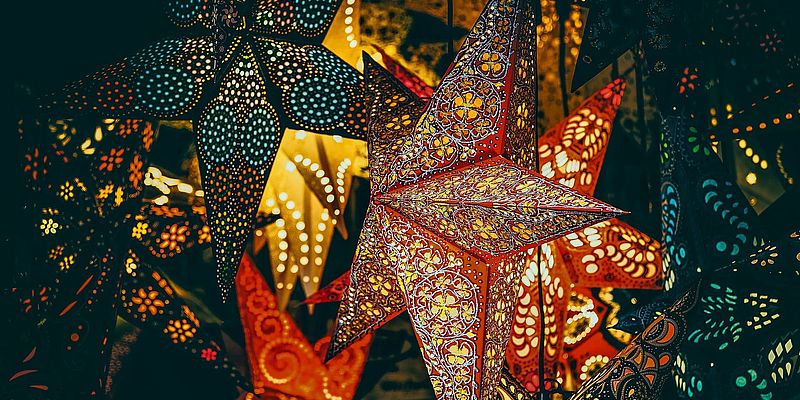 Leuchtende Papiersterne als Dekoration auf einem Weihnachtsmarkt
