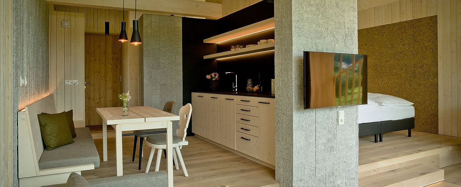 Chalet mit hohen Holzdecken und moderner Einrichtung, Küche, Bett, Sofa und TV