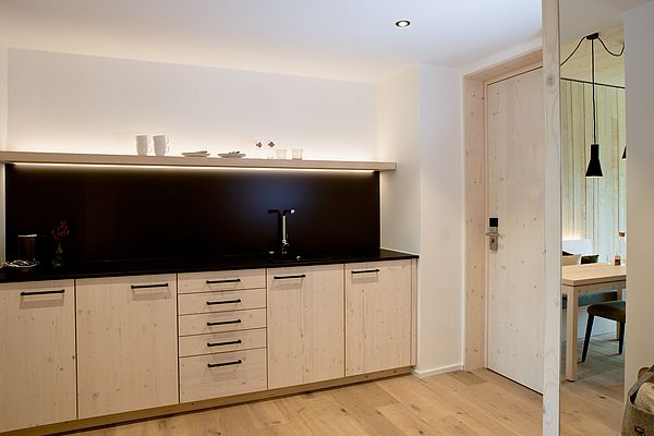 Suite mit stilvoller Küchenzeile mit Holzmöbeln und Parkettboden