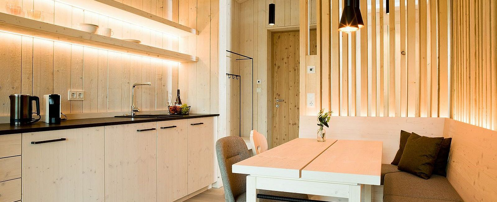 Gemütliche Wohnküche mit viel Licht und Möbeln aus hellem Holz