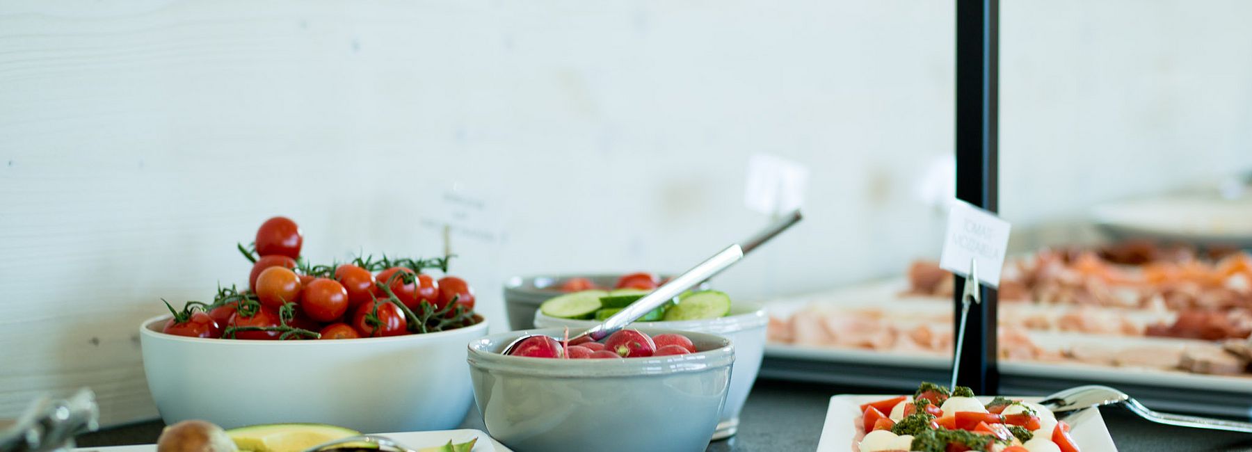 Frühstücksbuffet mit Tomaten, Mozzarella, Eiern, Avocado, Tomaten und Radieschen