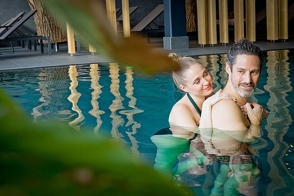 Pärchen kuschelt im Pool des Wellnessbereichs