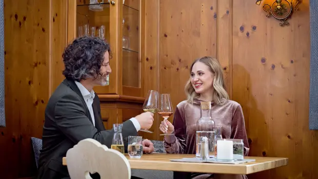 Paar stößt mit Weingläsern im Restaurant an