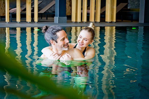 Pärchen kuschelt im Pool des Wellnessbereichs