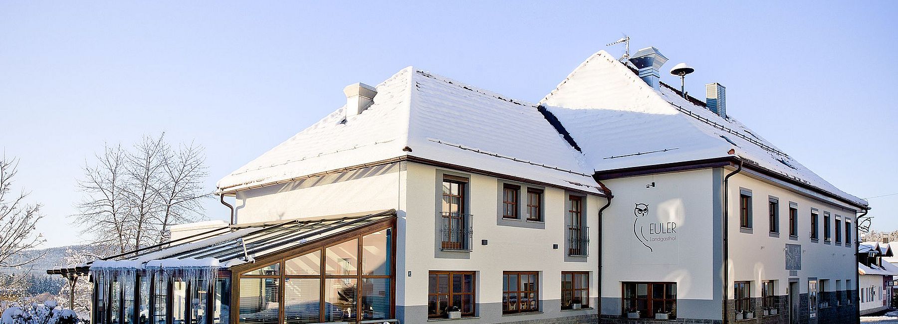Verschneiter Euler Landgasthof in Neuschönau im Winter bei Sonnenschein
