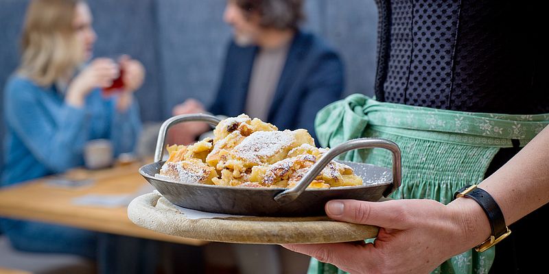 Kellnerin serviert Kaiserschmarrn für Pärchen im Restaurant des Euler Landgasthofs