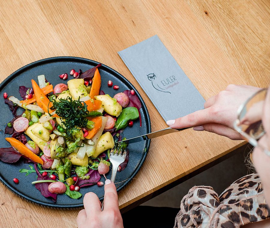 Gast isst Gemüsegericht mit Kartoffeln und Karotten