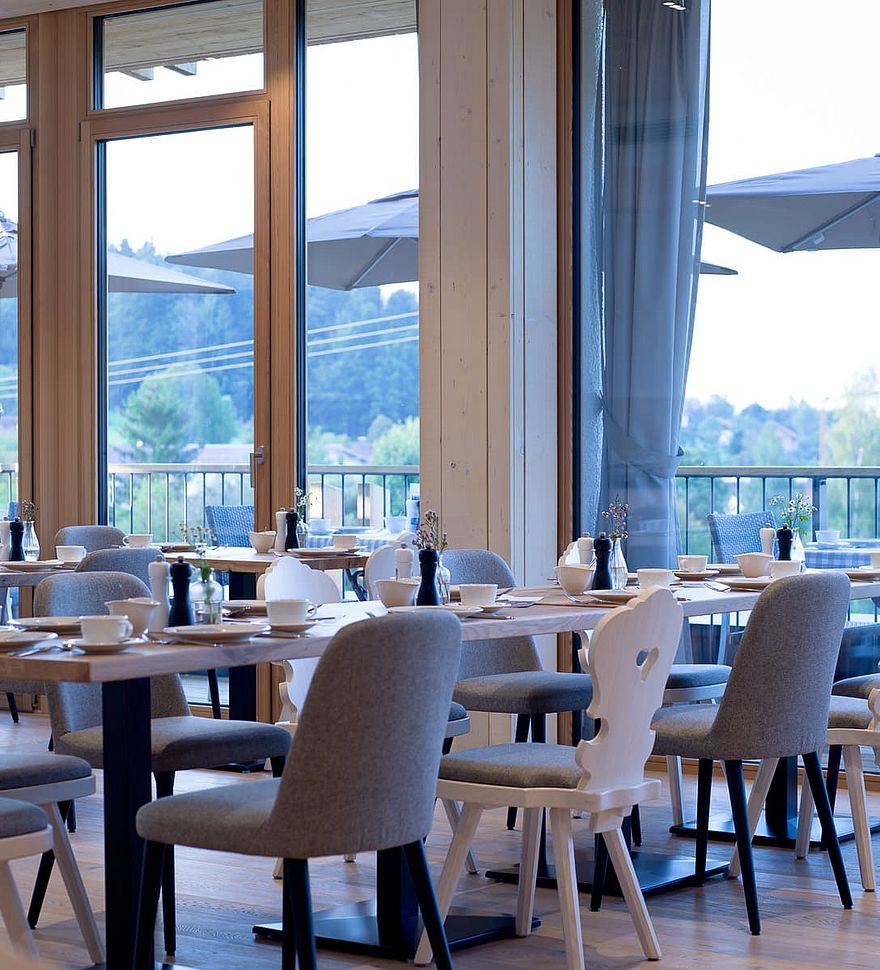 Modern restaurant dining area with large windows and countryside view