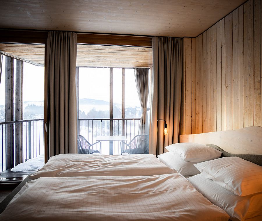 Bedroom with double bed and balcony view of snowy nature