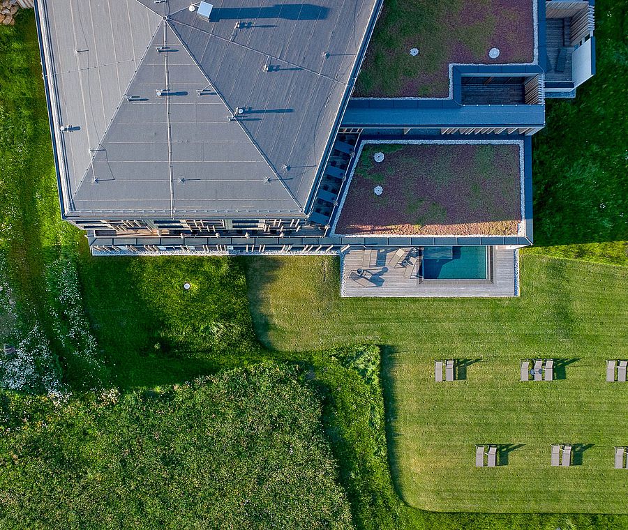 Luftaufnahme des modernen Hotels mit Dachterrasse und Grünflächen