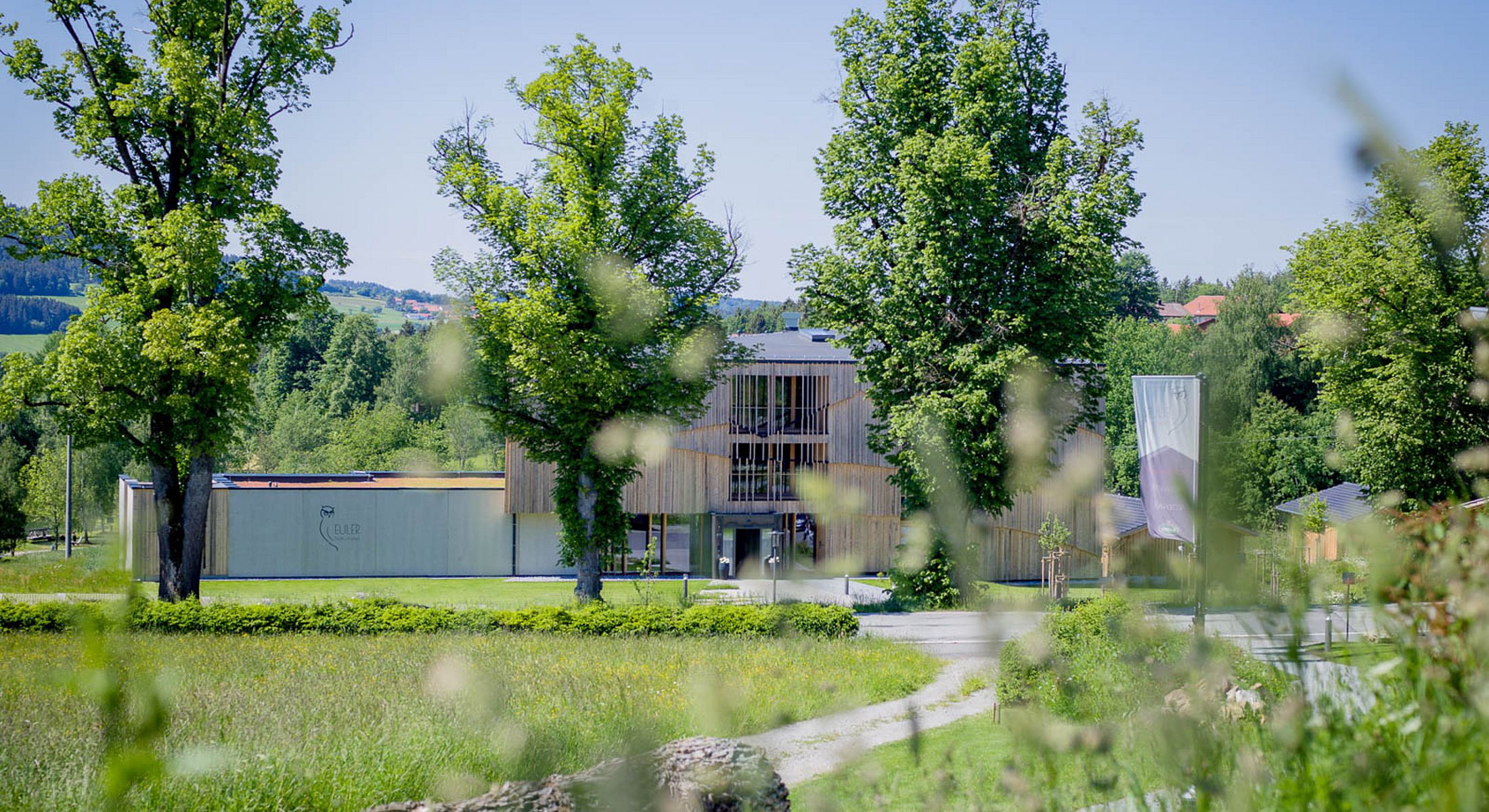 Modernes Hotelgebäude eingebettet in eine grüne Landschaft