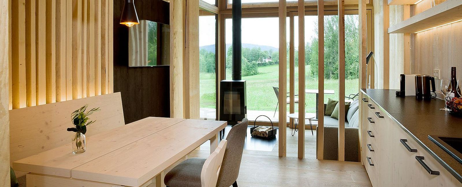 Blick aus dem Chalet mit gemütlicher Wohnecke mit Kamin und Küche mit Sitzecke