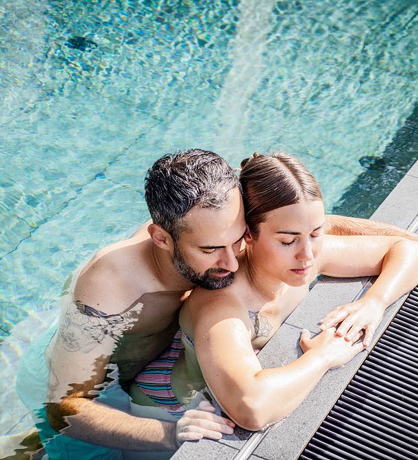 Paar entspannt gemeinsam im Außenpool des Naturhotels