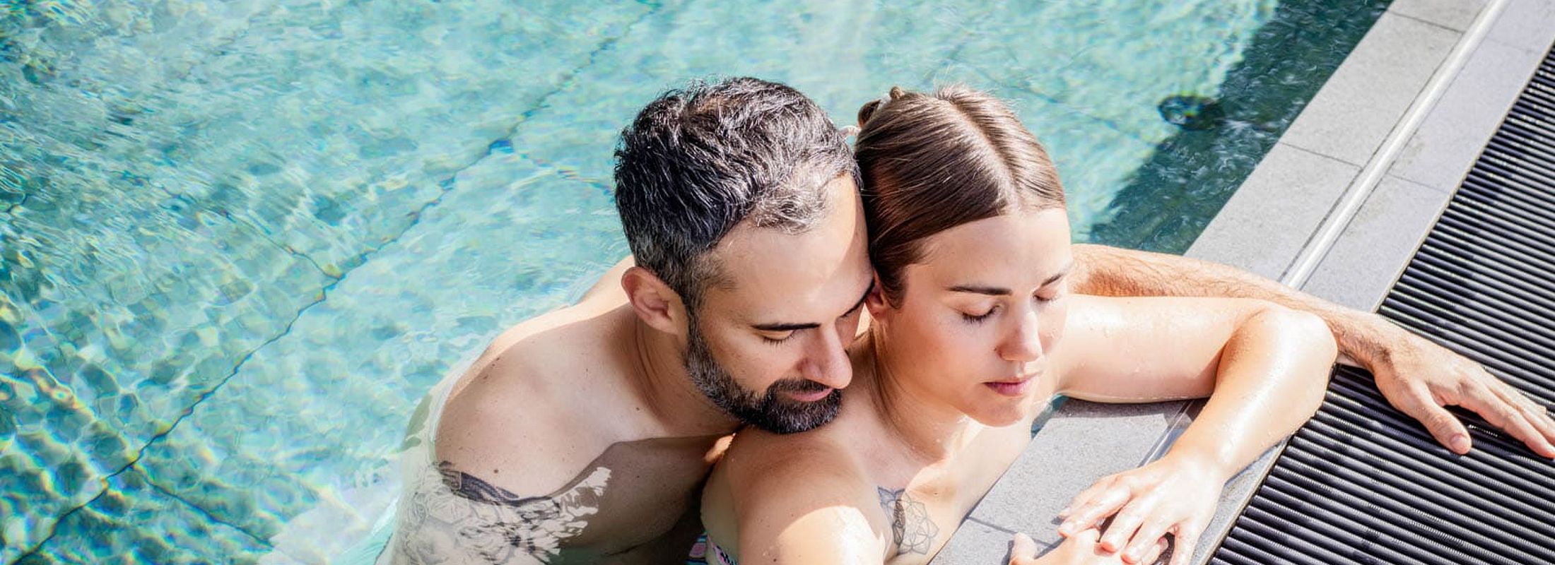 Couple relaxing together in the outdoor pool of the nature hotel
