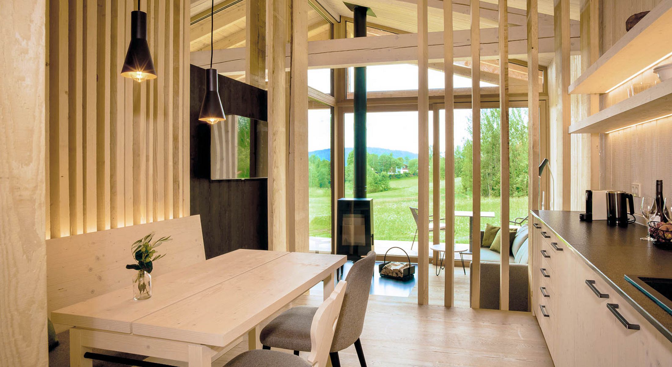 Modernes Chalet mit offener Küche, Essbereich und Blick ins Grüne