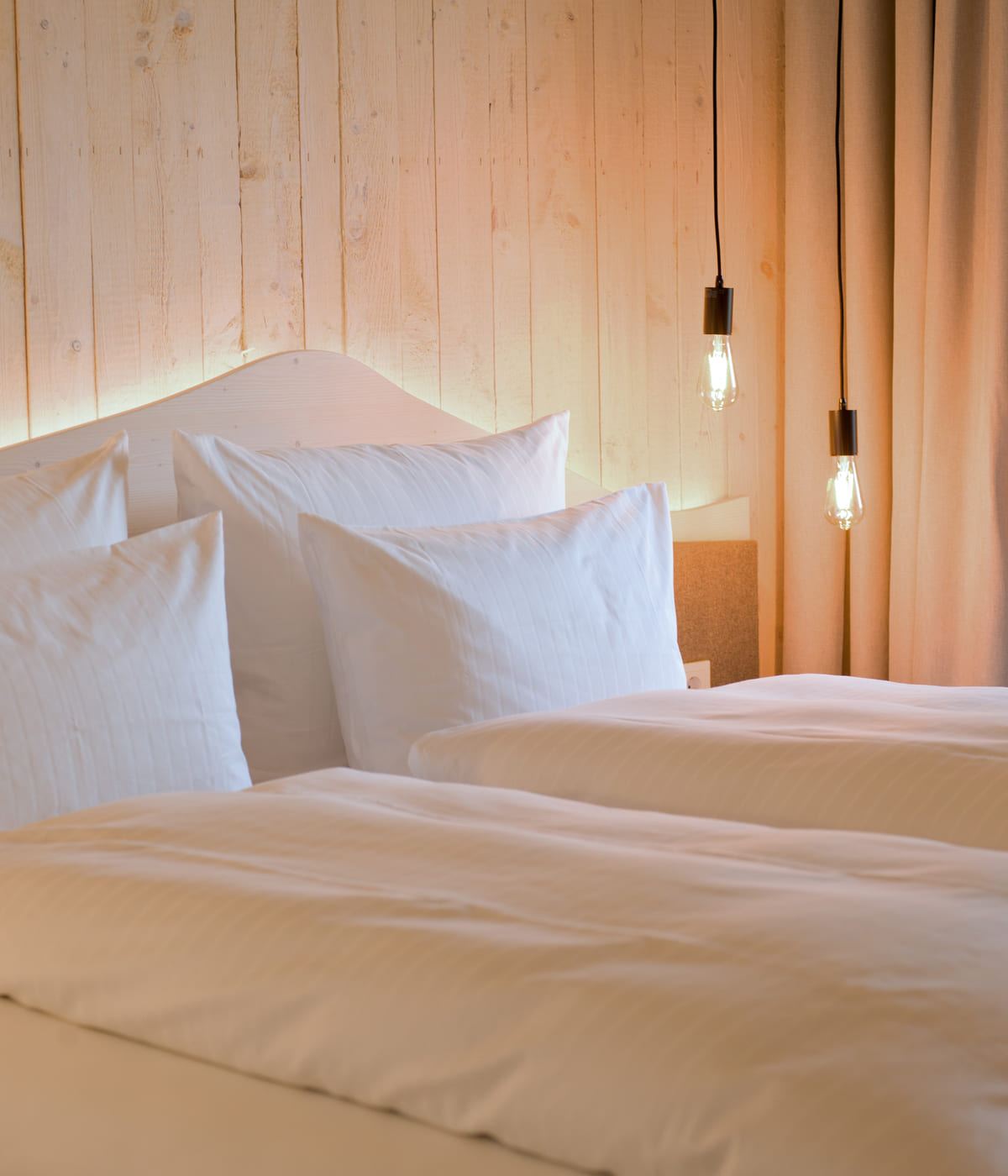 Helles Doppelbett mit Holzrückwand und gemütlicher Beleuchtung in modernem Zimmer